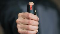 Man holding pepper spray (tear gas) in his hand. Self-defense. Blur background, close up