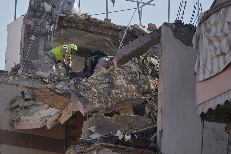 Rescue workers remove a dead body from a destroyed apartment that was hit in an Israeli airstrike in the southern port city of Sidon, Lebanon. Picture: AP Photo/Mohammed Zaatari