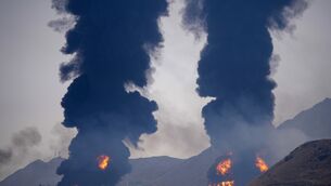 Plumes of smoke and fire rise after debris from an intercepted Iranian drone struck an oil facility, according to authorities, in Fujairah, United Arab Emirates (Altaf Qadri/AP)