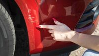 Scratches on the front bumper of a red car. A young girl driver got into a traffic accident and turns to a repair service.