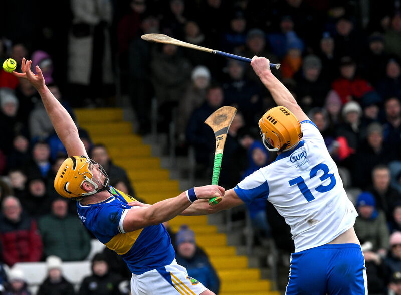 Both Ronan Maher of Tipperary and Seán Walsh of Waterford fail to catch the sliotar. Pic: McManus/Sportsfile