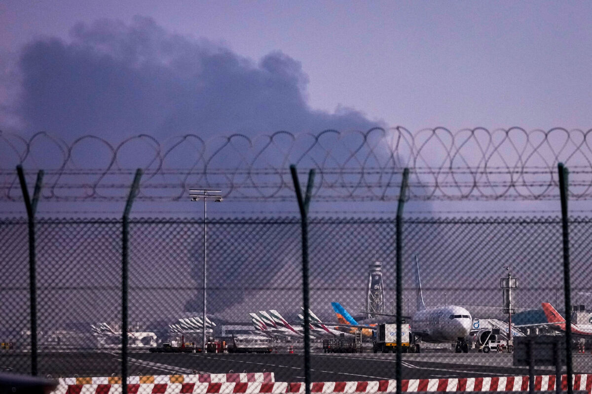Planes are parked at Dubai International Airport as smoke rises in the background after a drone struck a fuel tank early morning. Picture: AP Photo Planes are parked at Dubai International Airport as smoke rises in the background after a drone struck a fuel tank early morning. Picture: AP Photo