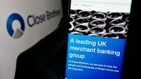 Person holding mobile phone with web page of British merchant bank company Close Brothers Group plc with logo. Focus on center o