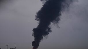 Fire and plumes of smoke rise after a drone struck a fuel tank forcing the temporary suspension of flights. near Dubai International Airport (AP)