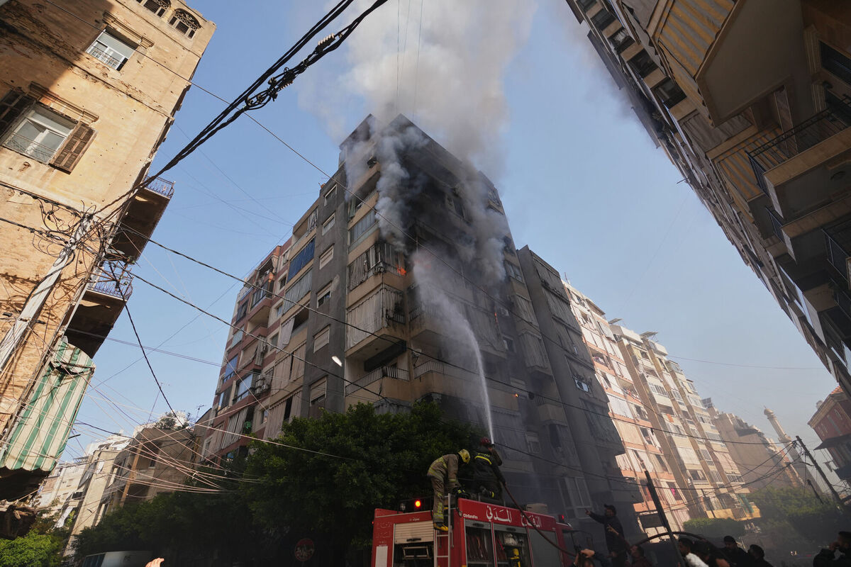 Firefighters spray water on a burning residential building following an Israeli airstrike in central Beirut, Lebanon, Wednesday, March 18, 2026. (AP Photo/Hassan Ammar)