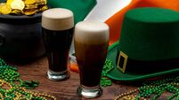 St Patrick's day party and Irish celebration of patron saint concept theme with frothy glasses of dry stout, green hat with a bu