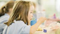 Young girl eating hot school dinner uk