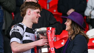 <p>Rachel O’Shea presents the cup to her son, captain Rían MacFarlane O'Shea of Presentation Brothers College. Pic: Paul Phelan/Sportsfile</p>