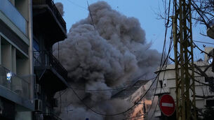 A building collapses as smoke rises following an Israeli strike in central Beirut (Hussein Malla/AP)