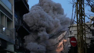 <p>A building collapses as smoke rises following an Israeli strike in central Beirut (Hussein Malla/AP)</p>