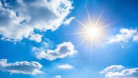 Sunny background, blue sky with white clouds and bright sun