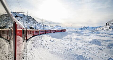 Bernina Express train traveling through snowy Swiss Alps panorama