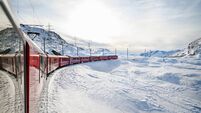 Bernina Express train traveling through snowy Swiss Alps panorama
