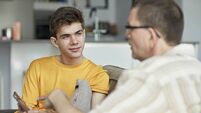 Parent and teenage son conversing at home