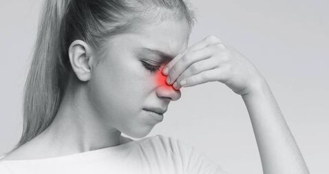 Sad woman holding her nose because sinus pain