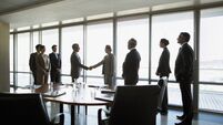Business people shaking hands in conference room