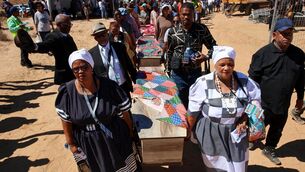 Coffins are carried during the reburial of remains of dozens of Africans (Jairus Mmutle/GCIS/AP)