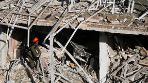 <p>An Israeli rescue officer at the site of an Iranian missile strike in Tel Aviv (Ohad Zwigenberg/AP)</p>