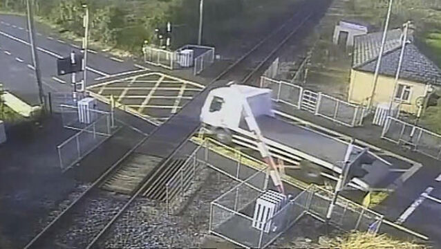 A truck has just been caught on film crashing through a gate while trying to beat a level crossing