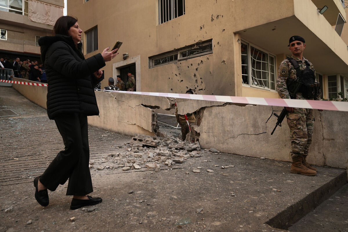 A woman passes an army soldier at the site where an intercepted missile fell in Sahel Alma, north of Beirut, Lebanon, on Tuesday, March 24. Picture: Hassan Ammar/AP