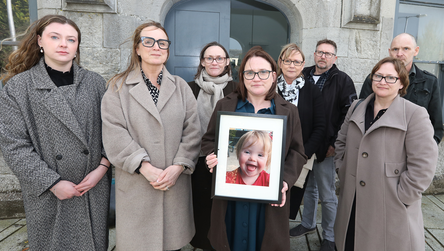 Paula Coote holding a photo of her daughter Nancy Coote with Aoife Bromley, Niamh Ní Mhurchú, Callan Tansey Solicitors, and Aileen Coote, Stephanie and Paddy Garrihy, and John and Gillian Coote, at the Coroners Court in Kilmallock.	Picture: Brendan Gleeson
            