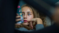 Young girl relax with her smartphone on a sofa