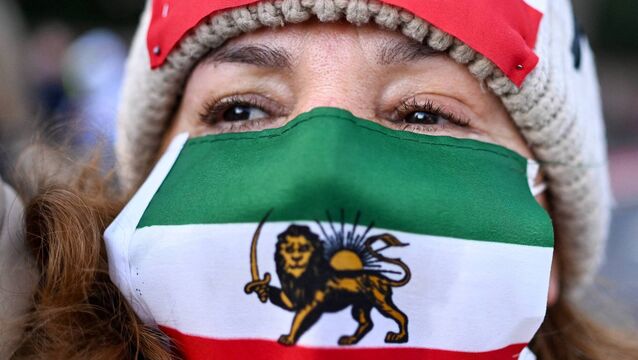 <p>A woman wearing a mask with the pre-1979 Iranian lion and sun flag at a protest in Frankfurt against the current regime in January. 	Picture: Kirill Kudryavtsev/AFP</p>