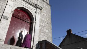<p>Reverend Meghan Farr, priest in charge at Saint Anne's Shandon, and Bishop of Cork, Cloyne, and Ross, Most Reverend Paul Colton celebrating the renovation work, including the newly-restored 300-year-old front doors. Picture: Clare Keogh </p>
