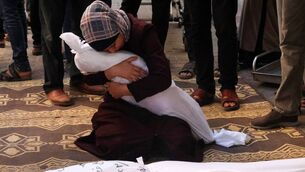 <p>Samia al-Atrash holding the remains of one of her sister's children from the Khoder family, killed in an Israeli bombardment in Rafah in Gaza on October 21, 2023. Picture: Said Khatib/AFP/Getty </p>
