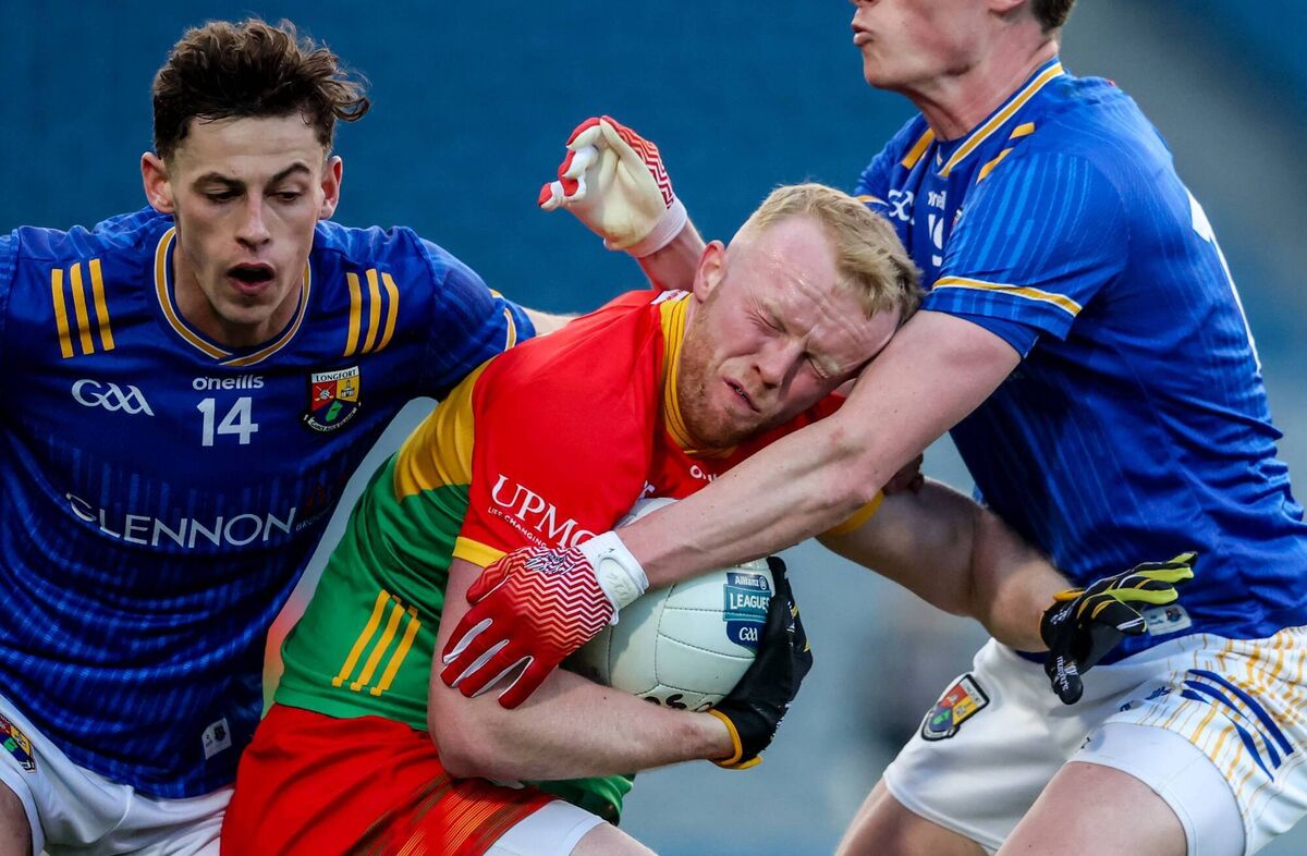 Carlow's Conor Doyle is tackled by Ronan Sweeney and Joseph Hagan of Longford. Pic: Inpho