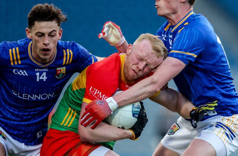 Carlow's Conor Doyle is tackled by Ronan Sweeney and Joseph Hagan of Longford. Pic: Inpho