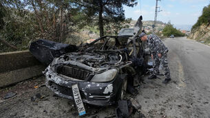 A policeman checks the charred car that was carrying Hezbollah’s al-Manar TV correspondent Ali Shoeib (Mohammed Zaatari/AP) A policeman checks the charred car that was carrying Hezbollah’s al-Manar TV correspondent Ali Shoeib (Mohammed Zaatari/AP)