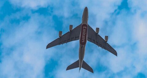 Emirates flight flying high in the sky