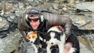 Rescue Wayne Holmes holds his dog Bingo, left, after the rescue of Molly, right, at a waterfall on the Arahura River (Precision Helicopters Ltd/AP)