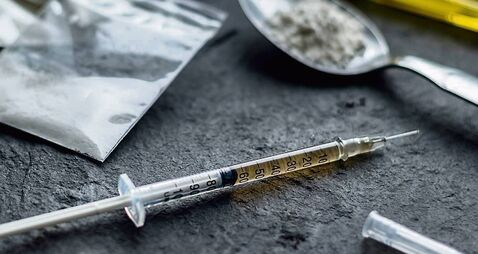 drug syringe and cooked heroin on spoon. drug addict problem and therapy concept