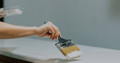 A young girl is painting an old closet.