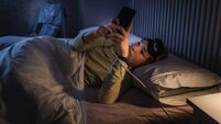 Teenage girl suffering sleeping disorders using smartphone at night