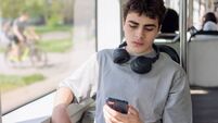 Teenage boy with smartphone looking tired and worried, digital overload and cyberbullying concept, ADHD and mental health challe
