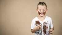 Little boy holds a bar of chocolate in his hand