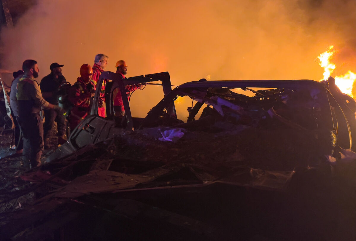 Rescue workers inspect the scene of an Israeli airstrike as fires burn among damaged vehicles, in Beirut, Lebanon, Wednesday, April 1, 2026. (AP Photo/Hussein Malla)