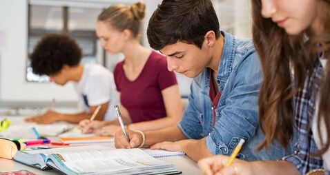 High school students doing exam in classroom