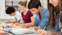 High school students doing exam in classroom