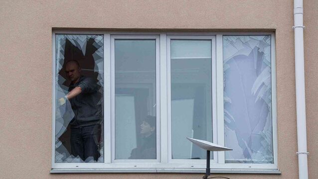 People remove broken glass from their windows after a Russian strike on a residential neighbourhood in Kriukivshchyna, Kyiv region, Ukraine (Evgeniy Maloletka/AP)