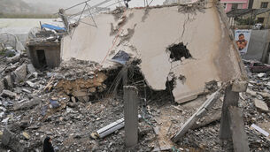 A woman checks a destroyed house that was hit in an Israeli airstrike in Saksakiyeh village, south Lebanon (Hussein Malla/AP)