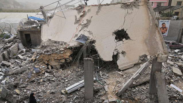 A woman checks a destroyed house that was hit in an Israeli airstrike in Saksakiyeh village, south Lebanon (Hussein Malla/AP)