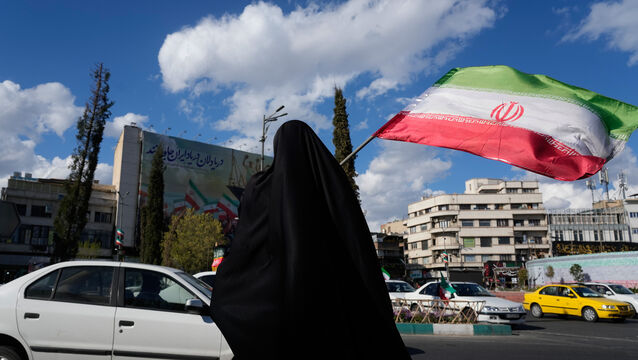 A woman waves an Iranian flag during a campaign in support of the government at the Enqelab-e-Eslami, or Islamic Revolution, square in downtown Tehran, Iran (Vahid Salemi/AP)