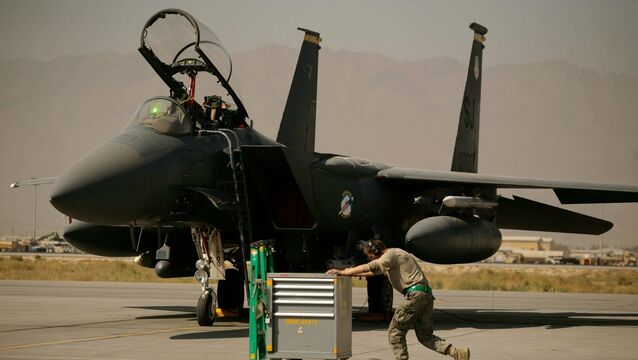 A US Air Force airman pushes a cart past an F-15E Strike Eagle at Bagram Air Field in Afghanistan (Maya Alleruzzo/AP)