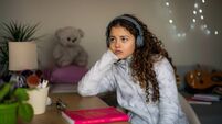 Unhappy teen girl wearing headphones feeling isolated and depressed
