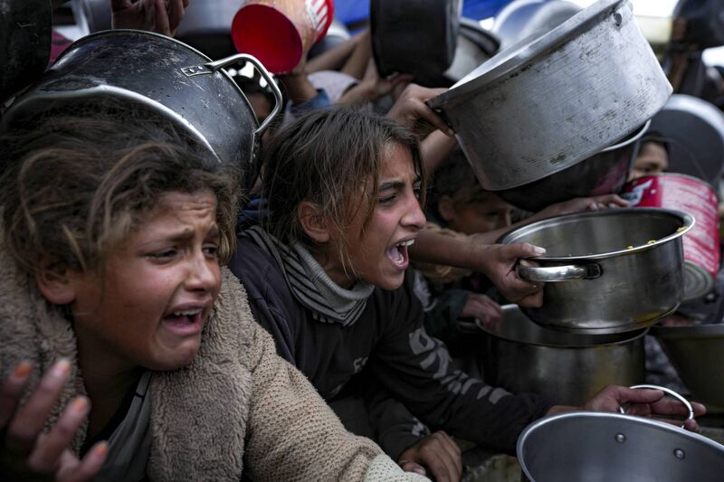 Palestinian girls struggle to reach for food at a distribution center in the Gaza Strip. Photo: AP/Abdel Kareem Hana Palestinian girls struggle to reach for food at a distribution center in the Gaza Strip. Photo: AP/Abdel Kareem Hana
