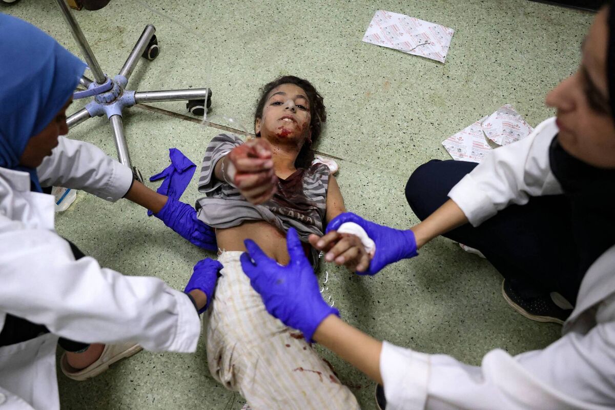 A young Palestinian girl extends her hand as she gets medical care for her injuries sustained in an Israeli strike near Khan Yunis in the southern Gaza Strip. Photo: Bashar Taleb/AFP